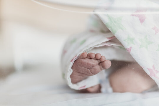 Close up image of newborn foot in bassinet at hospital after birth