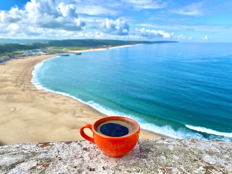 coffee overlooking the sandy Atlantic coast city of Nazare Portugal