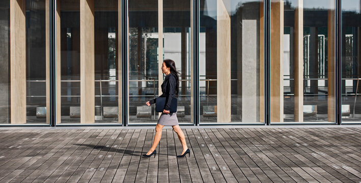 Business woman walking past modern building in Paris