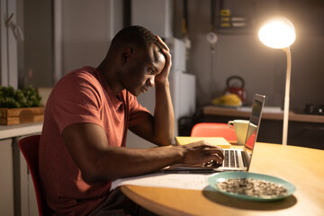 Tired black student using laptop