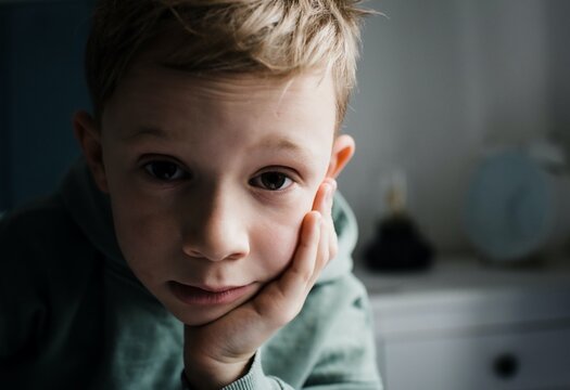 8 year old boy looking tired, thoughtful and expressive at home