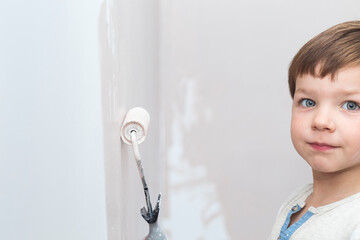 3 years cute little boy with paint roller in hand