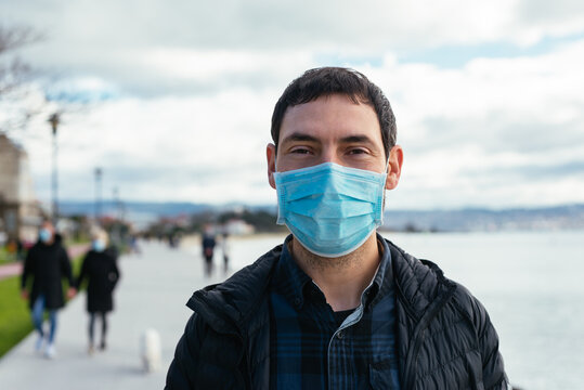 Portrait of a young man on the street wearing a face mask