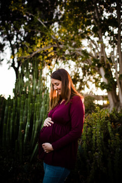 Pregnant Mid Thirties Woman Standing in Garden at Sunset in San Diego