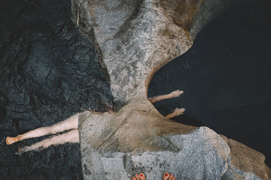 Woman Swims Through Stone Passage, Divided. Red Toes