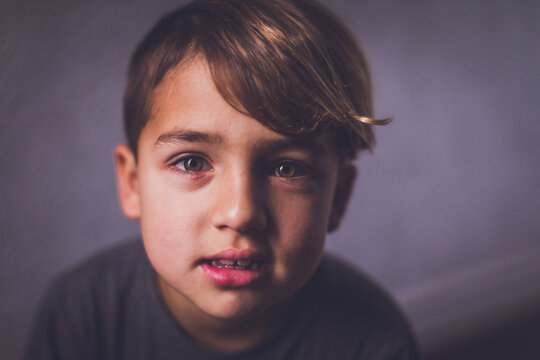 Boy with hazel eyes looking at the camera with an enigmatic look.