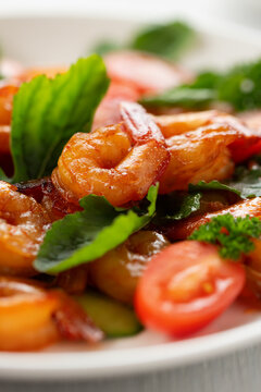 Close-up of fresh shrimp, tomato, arugula and greens salad, vertical image
