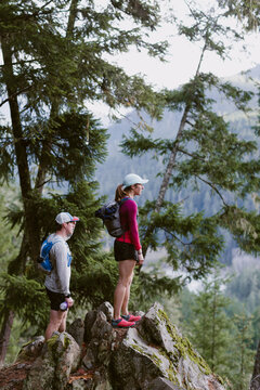 Female and male trail runners stop to take in the view of mountains