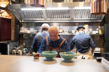 Male cooks working behind counter in cafe