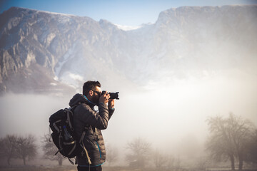 portrait of handsome man trekking in mountains in winter outdoo