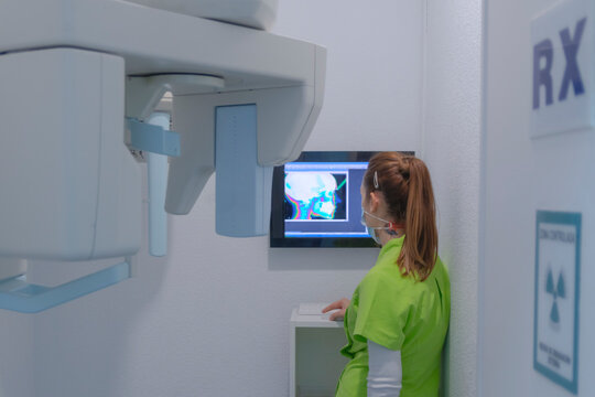 Woman dentist with mask checking an x-ray scan in dental clinic