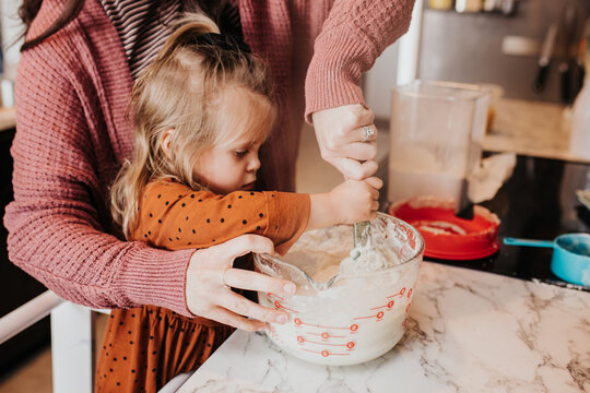 Mother And Daughter Feeding Sour Dough Starter In The Kitchen