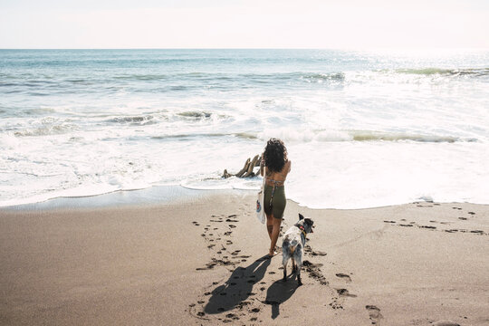 Woman taking pictures on the beach, with her dog. Photographer concept.