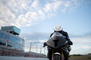 Anonymous racer riding motorcycle on cloudy day