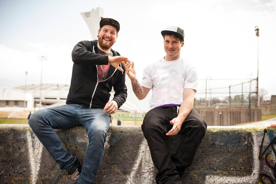 Two buddies bmxing and giving eachother a handshake