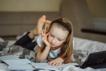 girl lying on the bed surrounded by notebooks
