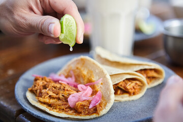 close-up unrecognizable man putting lemon inhis tacos with red onion