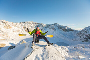 Paddler with raised arms after arriving at unexpected frozen lake.