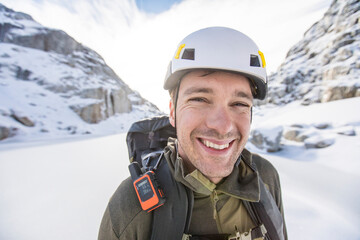 Portrait of a climber in mountains wearing helmet, GPS and backpack