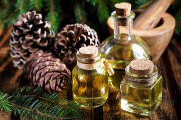 Bottles of pine essential oil with cones and branches