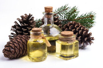 glass bottles with fir oil, cones and a branch of pine needles