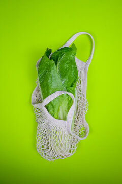 romaine lettuce in a string bag on a green background