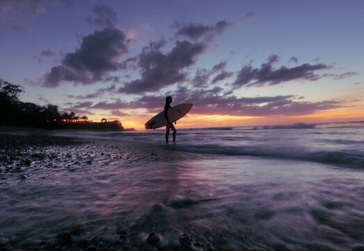Surfer Girl Silhouette Against Colorful Sunset