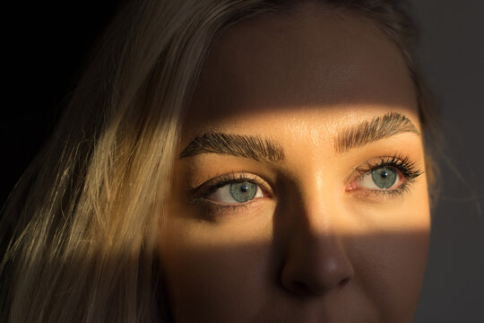 Close up with blue eyes of a woman looking out the window in the