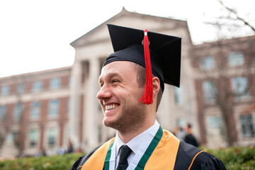 Portrait of proud young man in graduation cap and gown