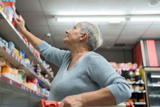 Caucasian senior adult woman shopping inside a supermarket