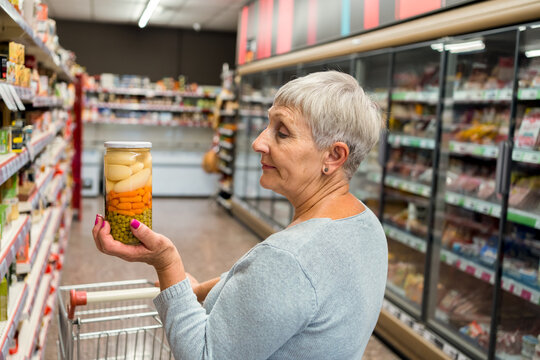 Caucasian adult woman with vegetable pot in supermarket