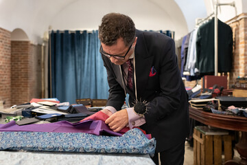 Mature man choosing fabrics in studio