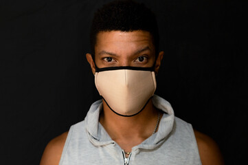 Young latin man with face mask and defiant look