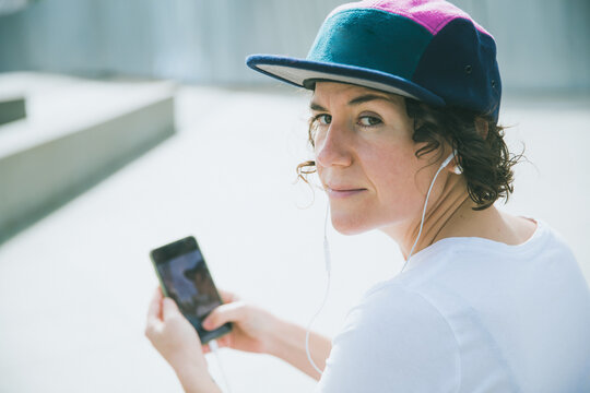 woman in cap listening to music with headphones
