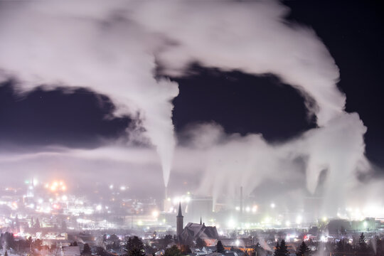 Huge Smokestacks and Foggy Cityscape at Night