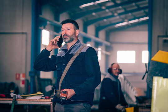 Man talking by telephone with the control of a bridge crane