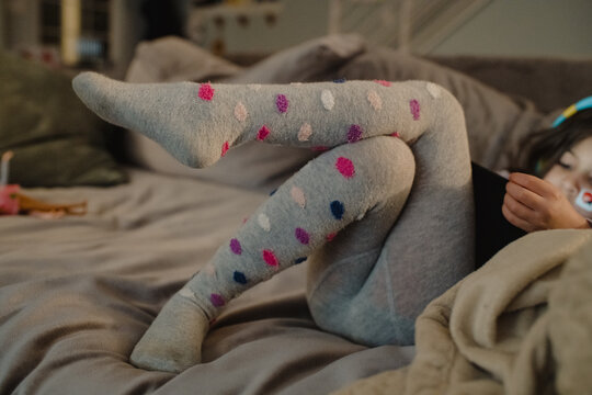 Child playing games on iPad wearing polka dot tights