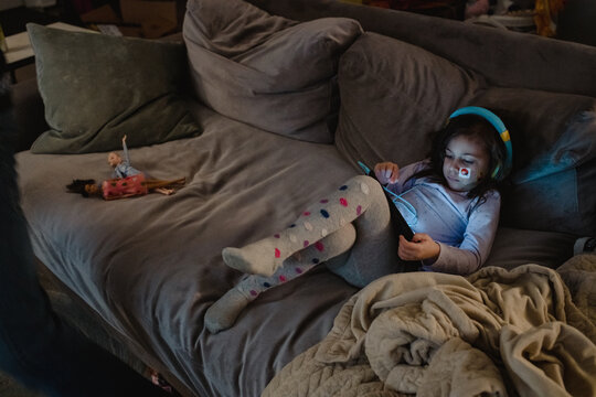 Multiracial girl using digital tablet on couch