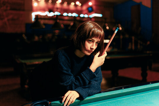 Young Girl Playing Pool In A Bar