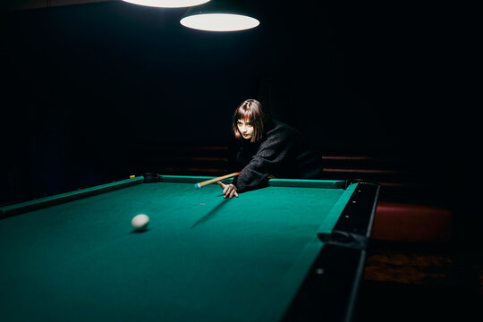 Young Girl Playing Pool In A Bar