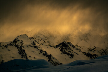 Scenic view of snowcapped mountain against cloudy sky during sunset