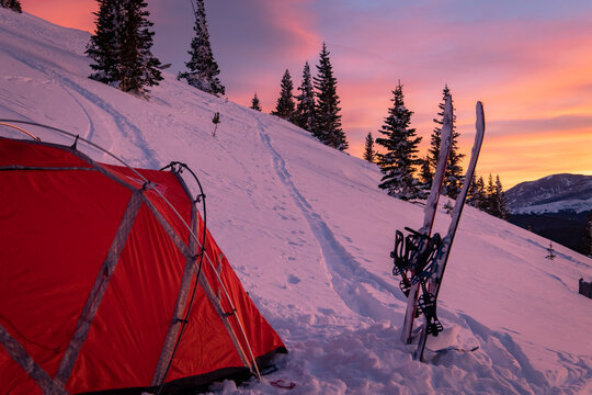 Splitboards by tent on snowcapped mountain during vacation