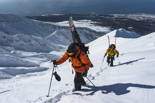 People with ski splitboarding on snowcapped mountain
