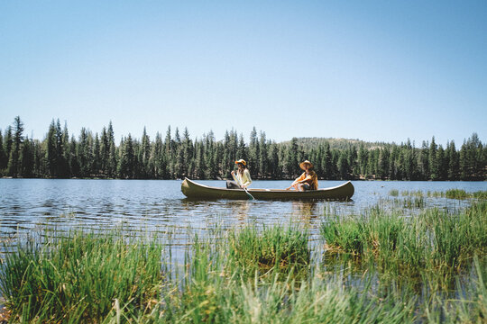 Mother and Son Paddle together in a Yellow Canoe. Scenic Sierra Lake.