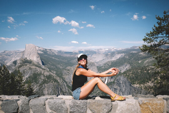 Woman Poses for a Photo on a Wall above Yosemite Valley