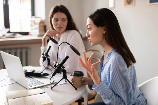 Asian blogger with coffee recording podcast with friend