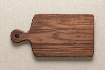 Handmade black walnut wooden cutting board on burlap.