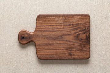 Handmade black walnut wooden cutting board on burlap.