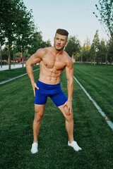 sporty man with muscular body pumping in park workout