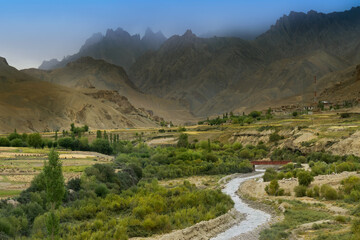 Top view of Indus river and Kargil City valley with Himalayan mountains and blue cloudy sky in background, Namkila pass, Ladakh, Jammu and Kashmir, India